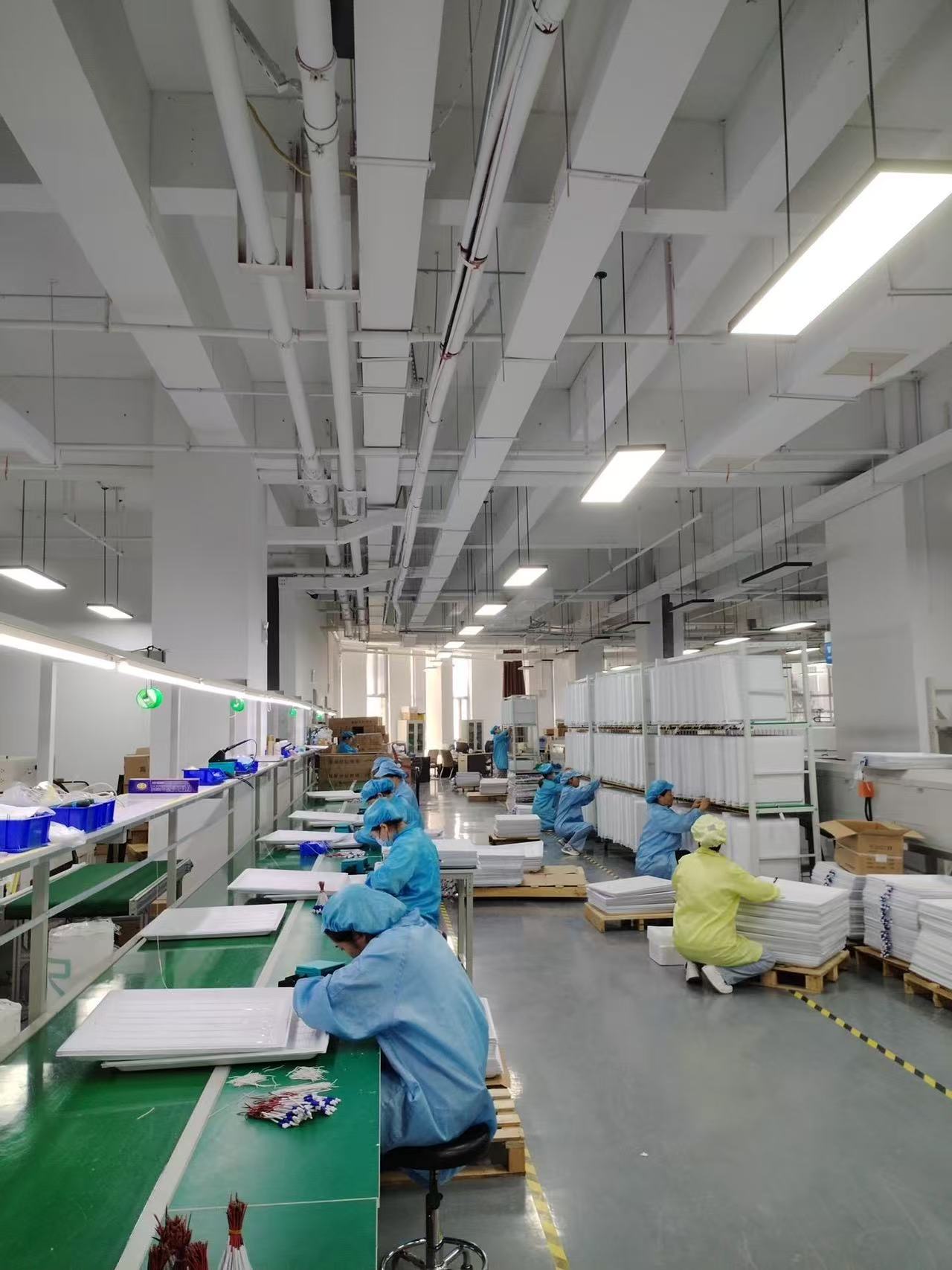 Lighting workshop floor with workers and fixture components